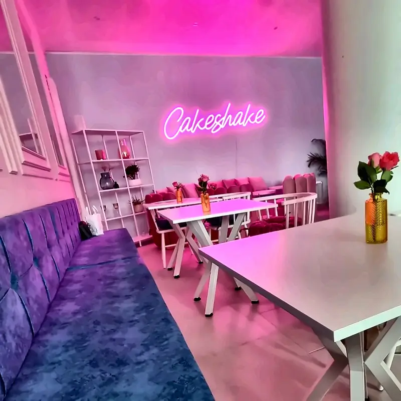 Leerer Gastraum mit Neonschrift und Sitzbänken